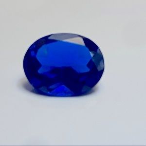 Approximately 9 x 11 mm oval synthetic blue sapphire